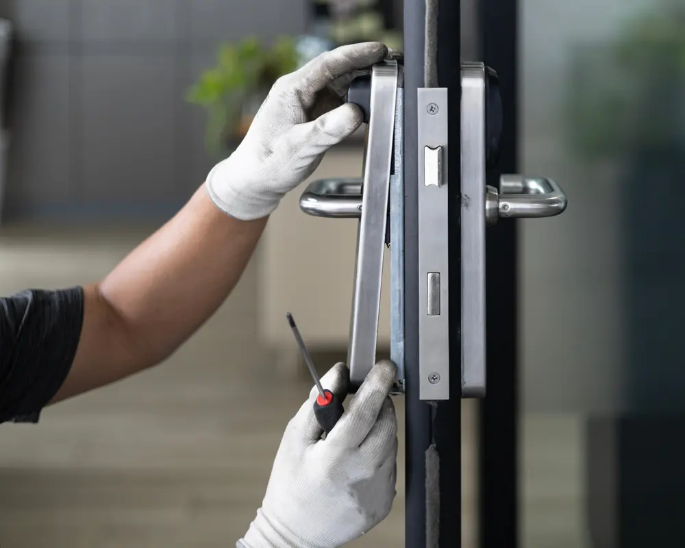 Locksmith fitting a mortice lock and handle plate to a door